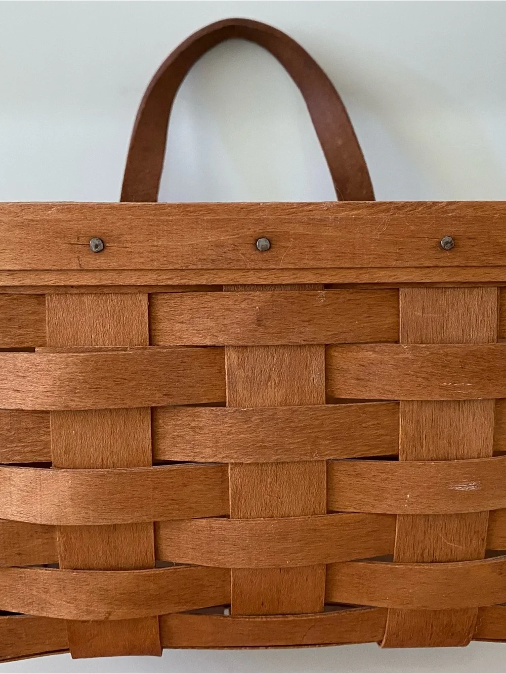 Vintage handwoven Longaberger Medium Key Basket with a leather handle.